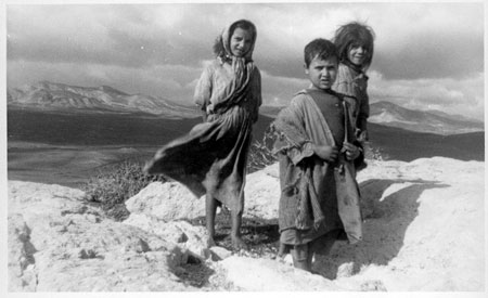 children, mountains and desert valley in background